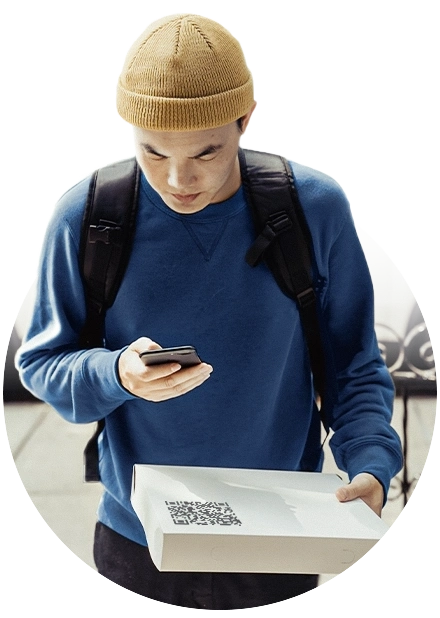 homem com celular apontando para caixa em sua mão com código qr representando recebimento por carteiras digitais