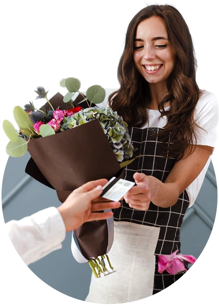 mulher com buquê de flores na mão pegando um cartão, representando contas a pagar e receber